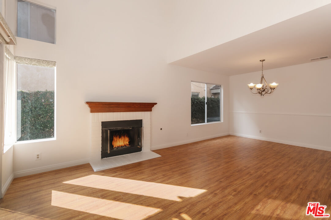 552 Fairfield Road Simi Valley, CA 93065 - Photo 3 of 13 a view of an empty room with wooden floor fireplace and a window