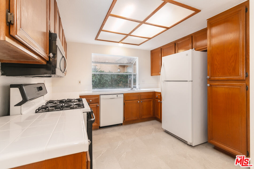 552 Fairfield Road Simi Valley, CA 93065 - Photo 5 of 13 a kitchen with a refrigerator a stove top oven a sink and dishwasher