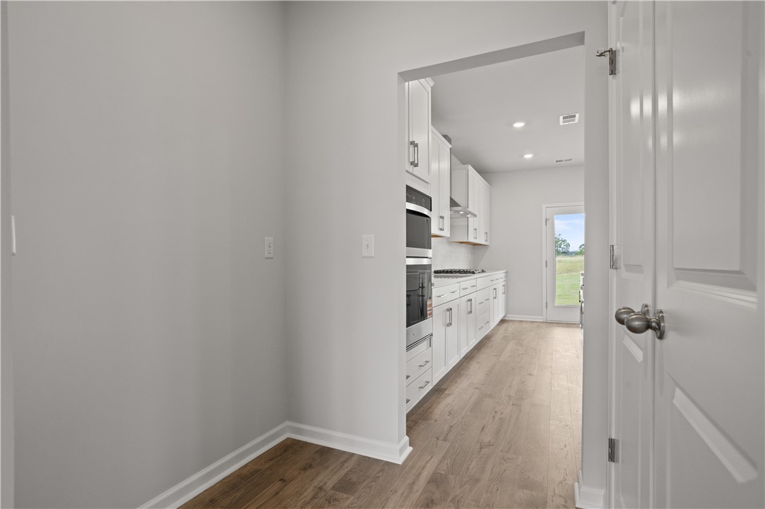 555 Hydrangea Street, Unit LOT 47 Seneca, SC 29678 - Photo 9 of 38 A well-appointed culinary space featuring built-in appliances and warm wood flooring.