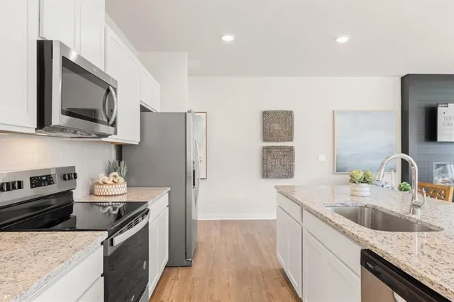 a kitchen with stainless steel appliances granite countertop a sink stove and refrigerator