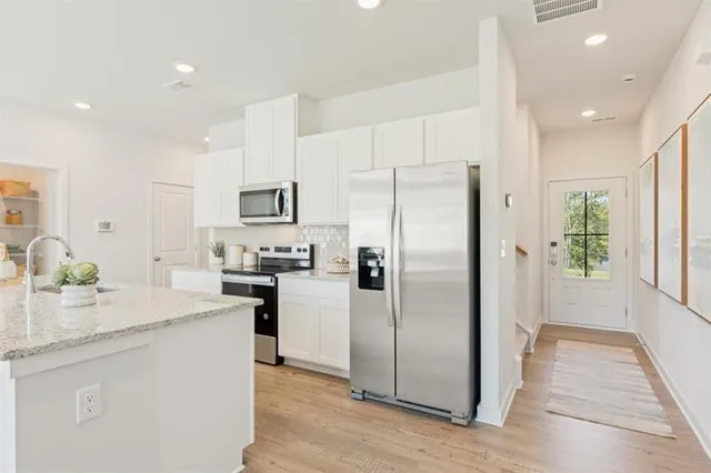 a kitchen with granite countertop a sink wooden cabinets and stainless steel appliances