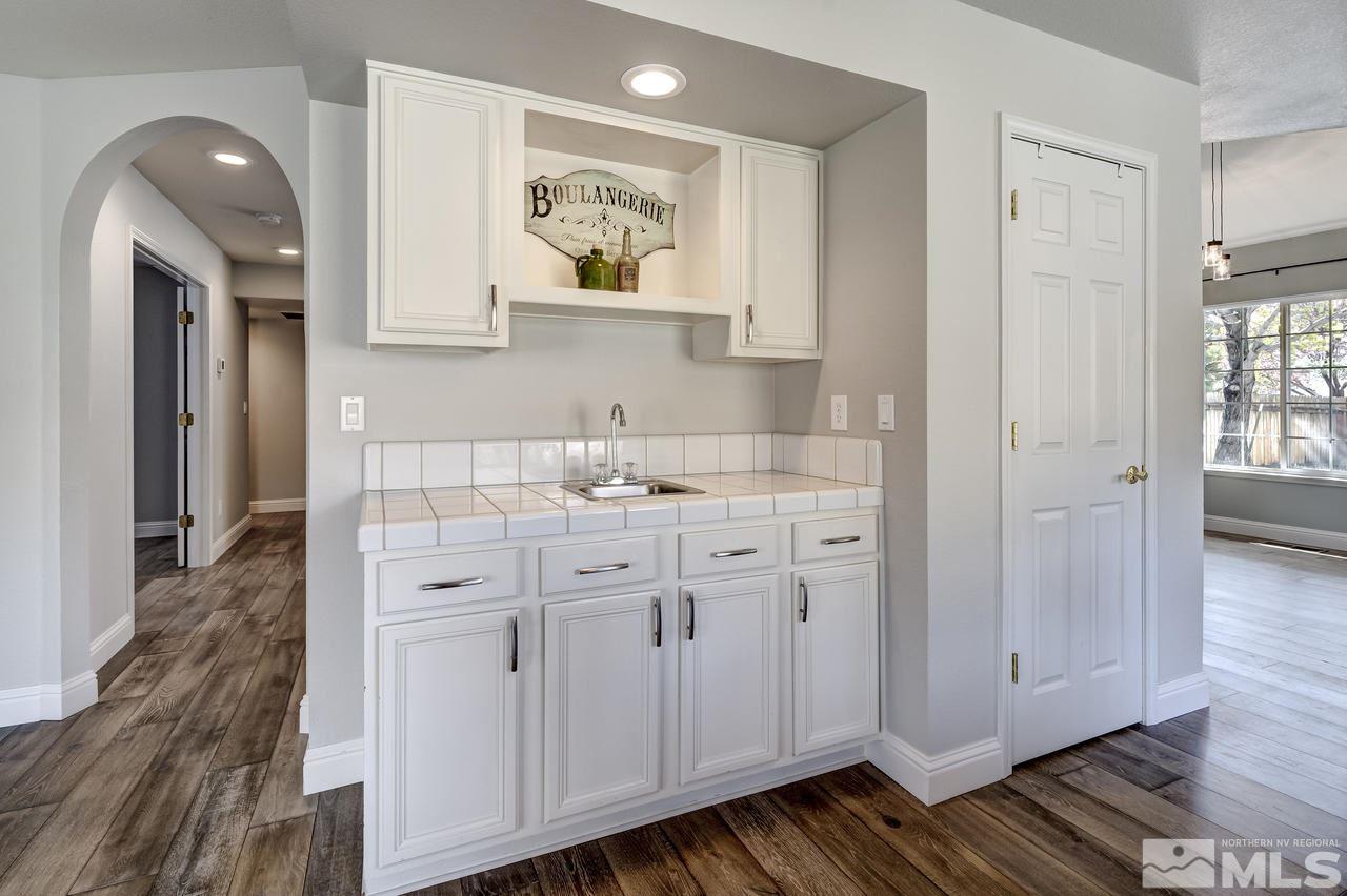 14435 Ghost Rider Drive Reno, NV 89511 - Photo 11 of 30 a kitchen with white cabinets and wooden floor