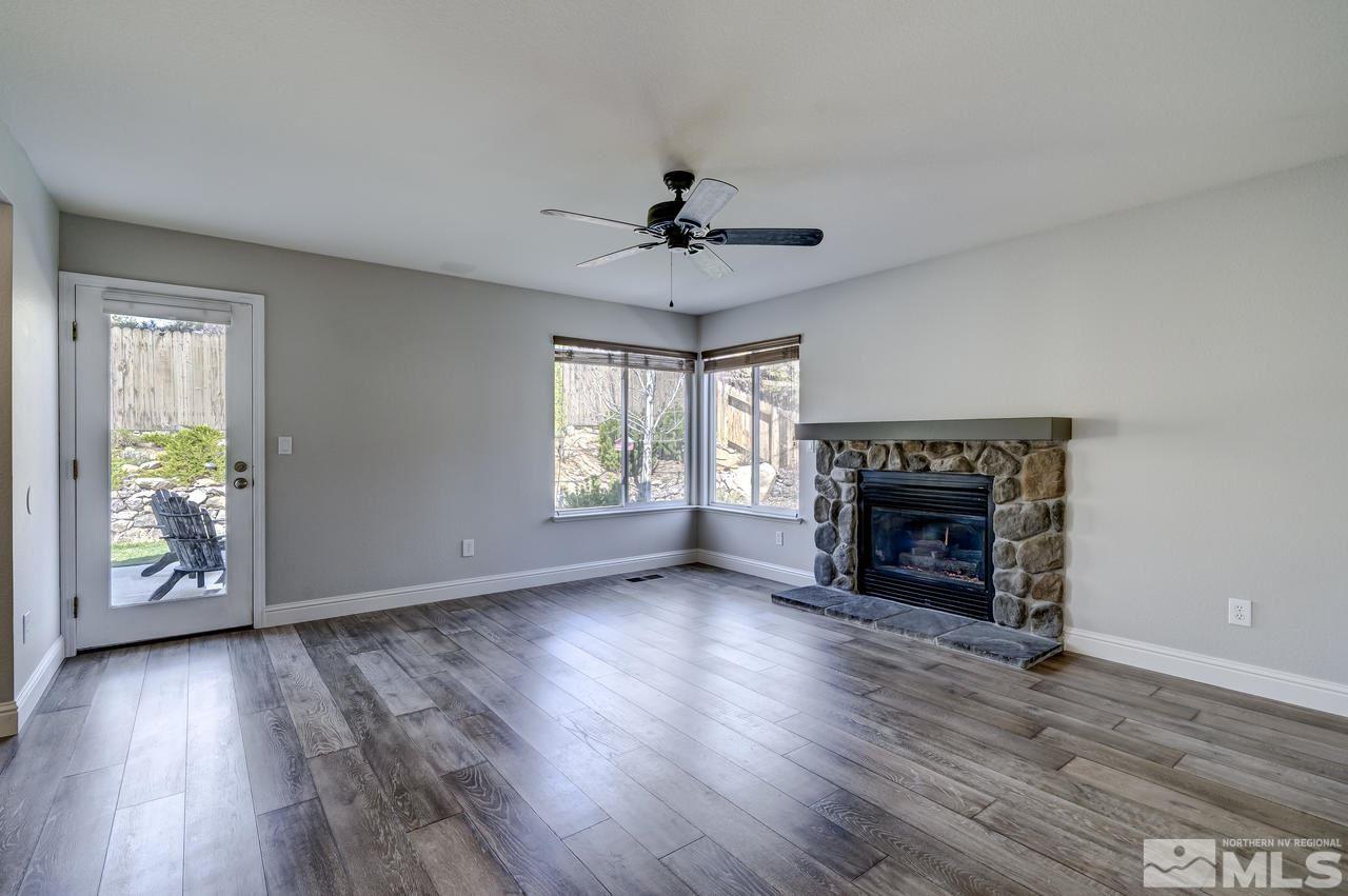 14435 Ghost Rider Drive Reno, NV 89511 - Photo 14 of 30 an empty room with wooden floor a ceiling fan and windows