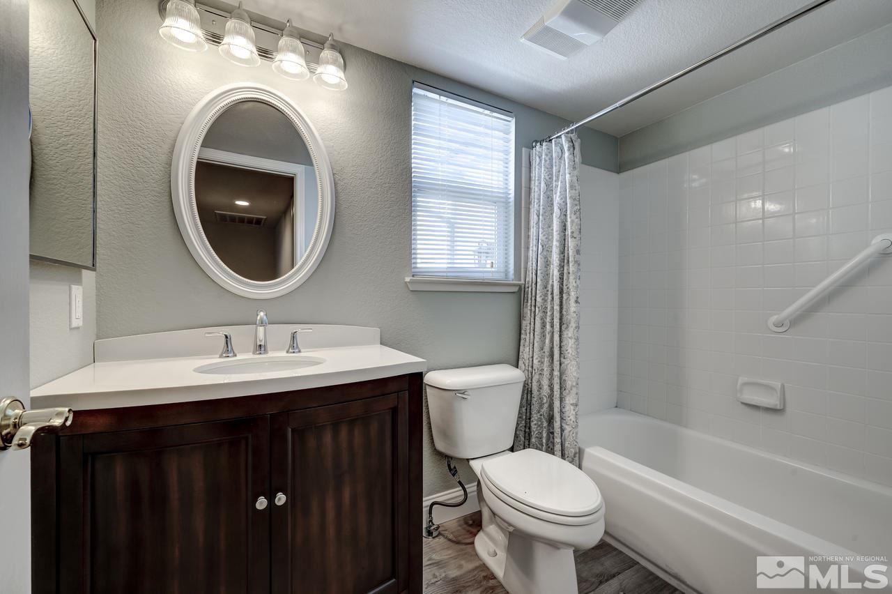 14435 Ghost Rider Drive Reno, NV 89511 - Photo 24 of 30 a bathroom with a toilet a sink and a mirror