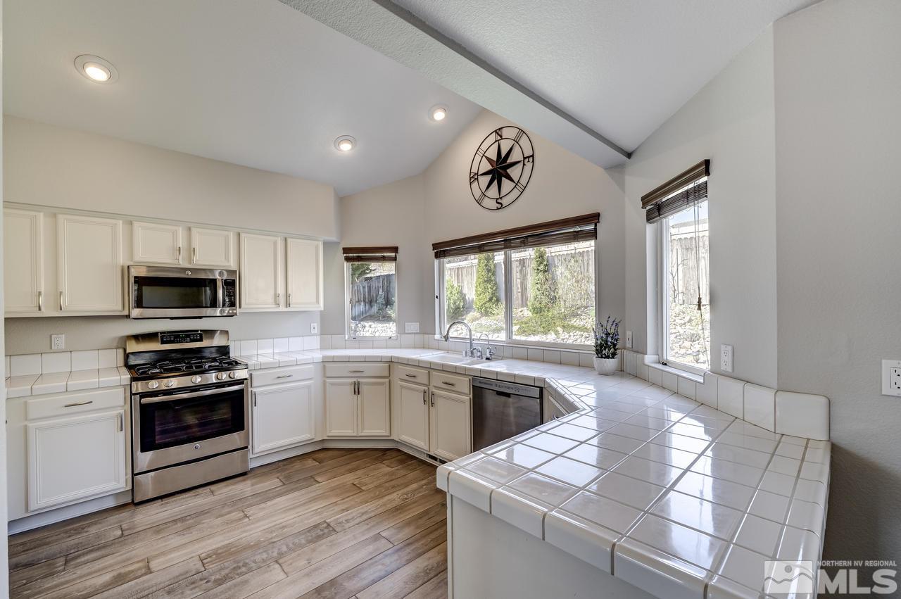 14435 Ghost Rider Drive Reno, NV 89511 - Photo 7 of 30 a kitchen with stainless steel appliances granite countertop a stove and a sink