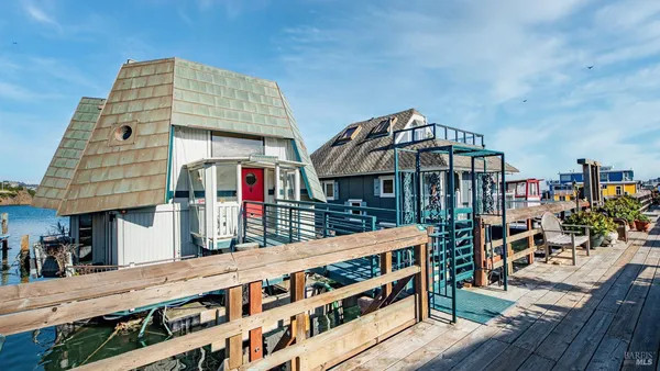 a living room with furniture and a dining table with wooden floor