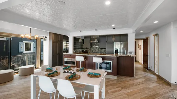 a living room with furniture kitchen view and large windows
