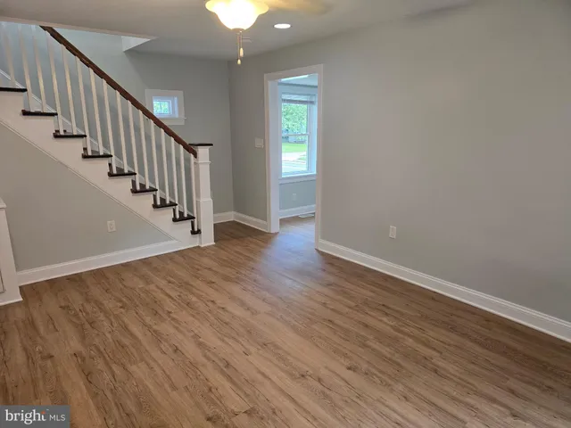 an empty room with wooden floor and entrance