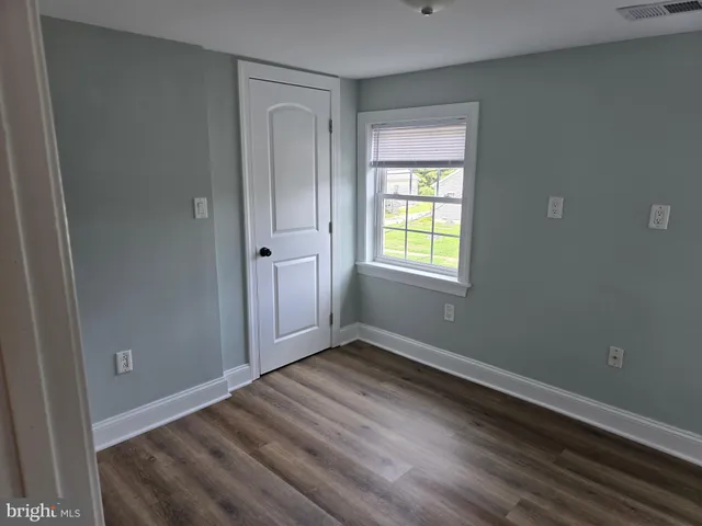 a view of empty room with wooden floor and cabinet