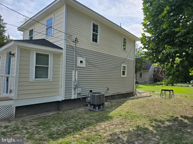 a view of a small house with yard and a large tree