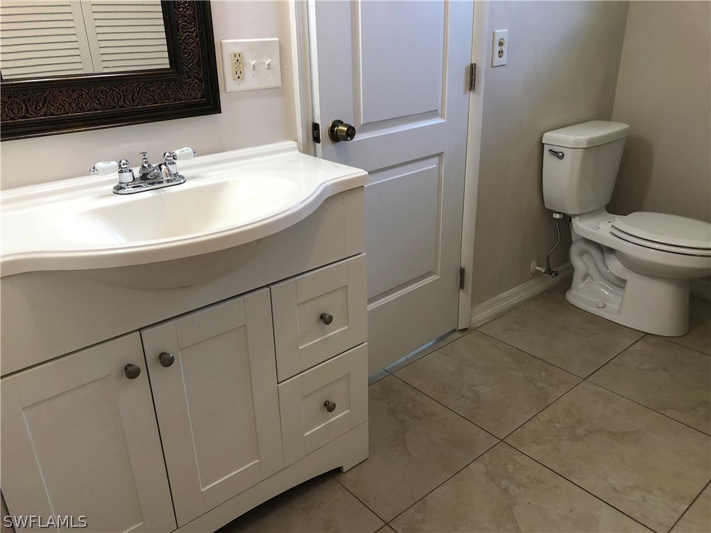 19 Connecticut Road Lehigh Acres, FL 33936 - Photo 14 of 26 a bathroom with a sink toilet and mirror
