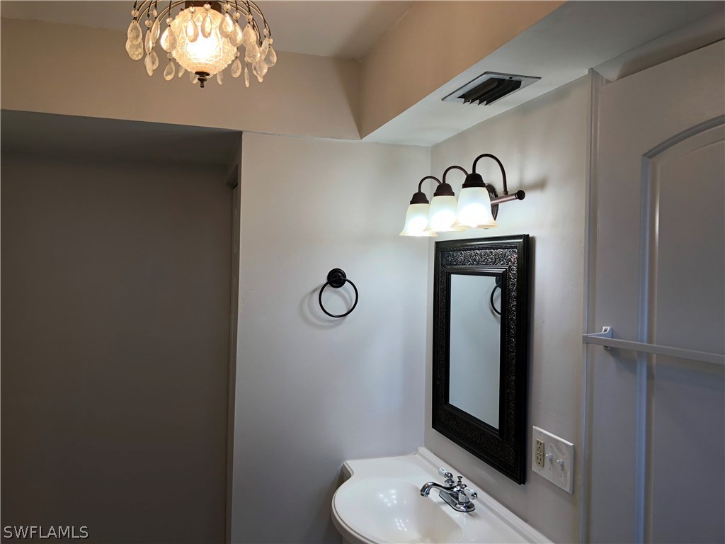 19 Connecticut Road Lehigh Acres, FL 33936 - Photo 15 of 26 a bathroom with a sink and a mirror