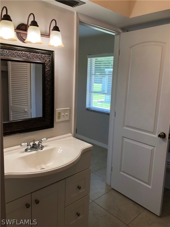 19 Connecticut Road Lehigh Acres, FL 33936 - Photo 16 of 26 a bathroom with a sink and a mirror