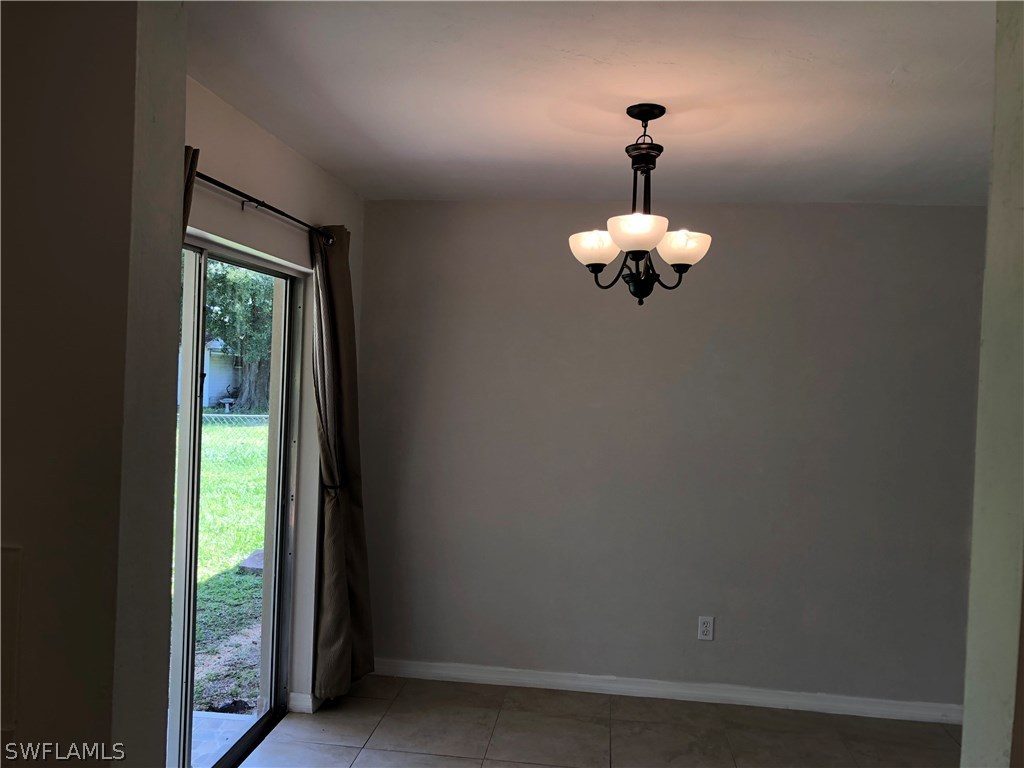 19 Connecticut Road Lehigh Acres, FL 33936 - Photo 20 of 26 a room with a window and a chandelier