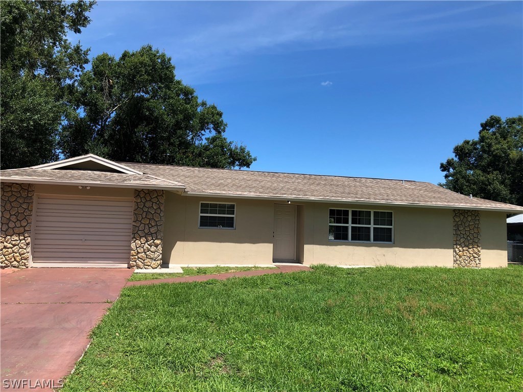 19 Connecticut Road Lehigh Acres, FL 33936 - Photo 2 of 26 a front view of house with yard and green space