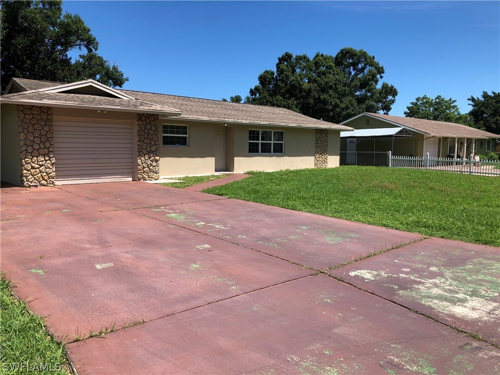19 Connecticut Road Lehigh Acres, FL 33936 - Photo 26 of 26 a front view of a house with a yard and garage