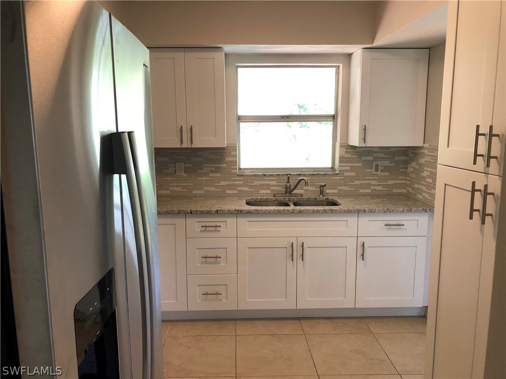 19 Connecticut Road Lehigh Acres, FL 33936 - Photo 6 of 26 a bathroom with a granite countertop sink and a mirror