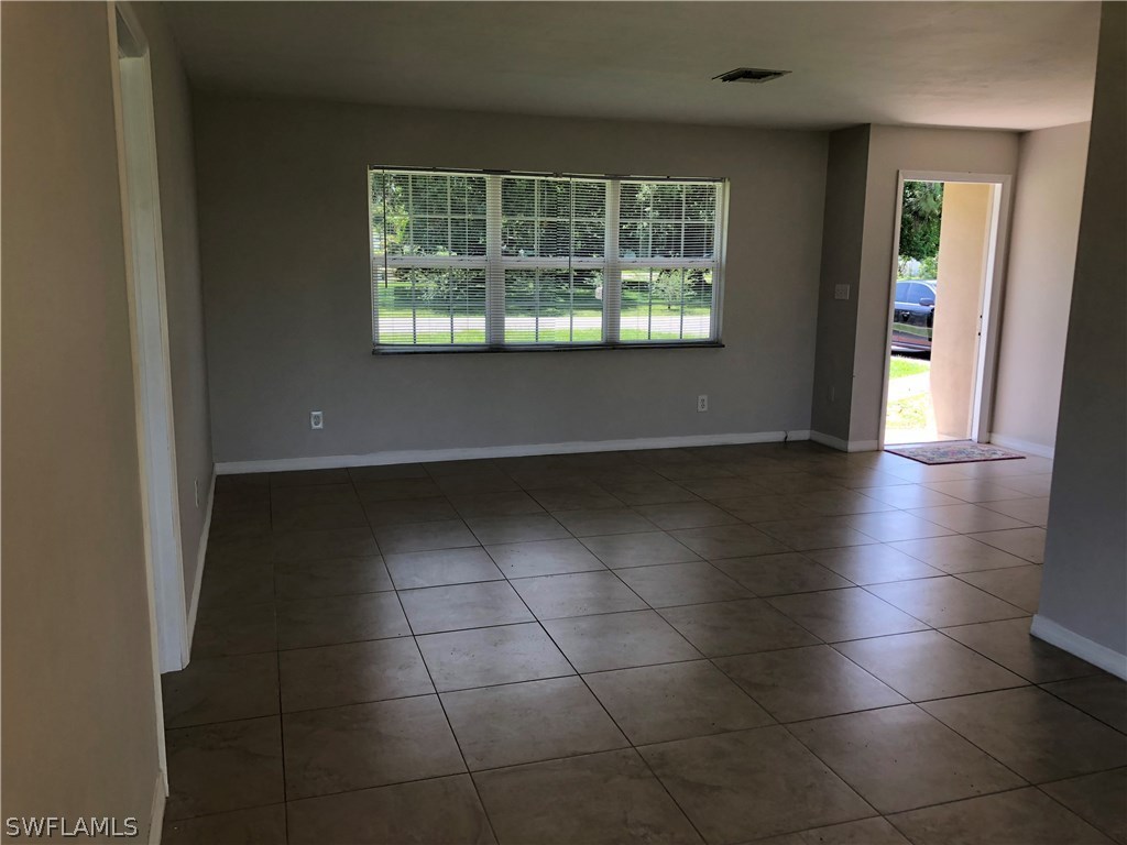 19 Connecticut Road Lehigh Acres, FL 33936 - Photo 8 of 26 an empty room with kitchen and windows