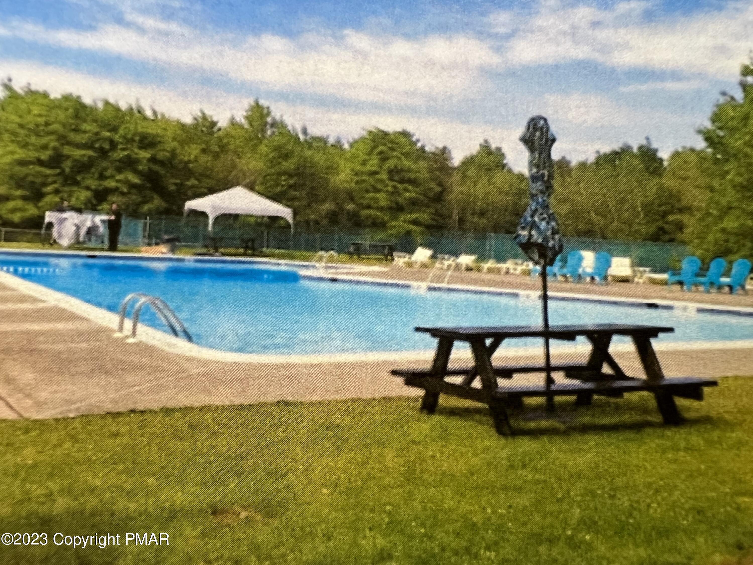 143 Granite Road Long Pond, PA 18334 - Photo 12 of 23 a view of a swimming pool with a table and chairs