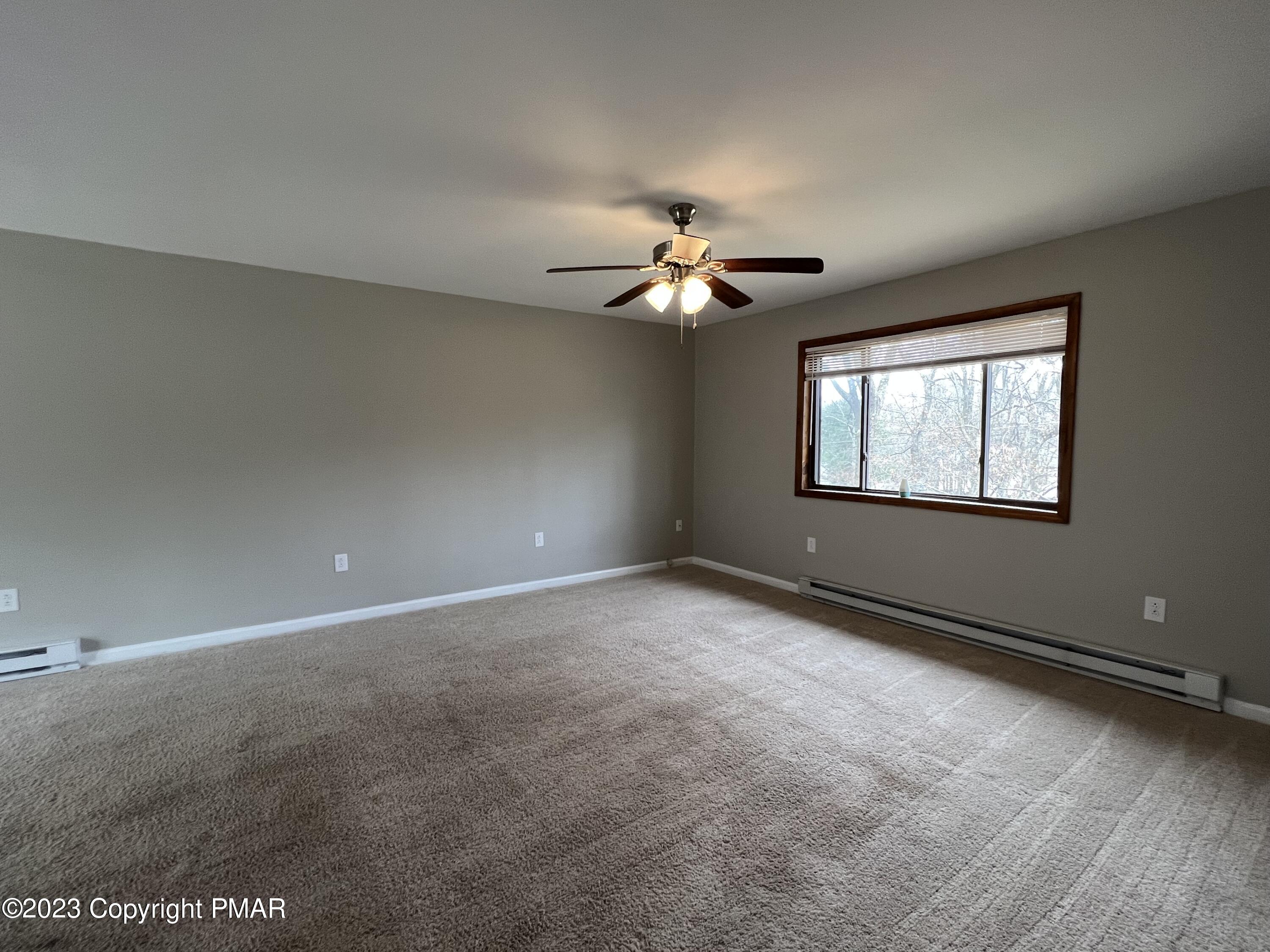 143 Granite Road Long Pond, PA 18334 - Photo 6 of 23 an empty room with windows and chandelier fan