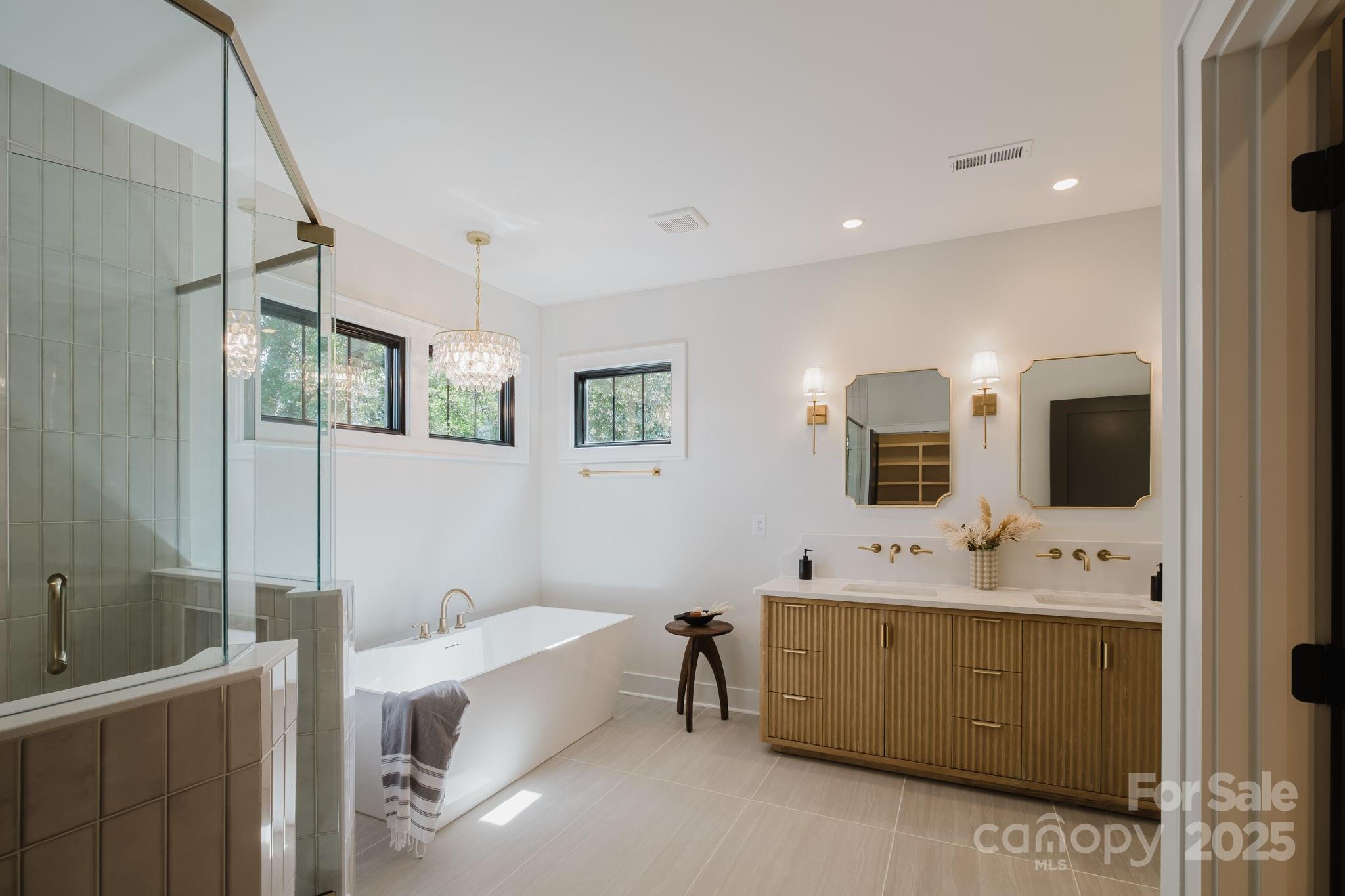 1625 Club Road Charlotte, NC 28205 - Photo 16 of 31 a en suite spacious bathroom with a double vanity sink a mirror and a bathtub