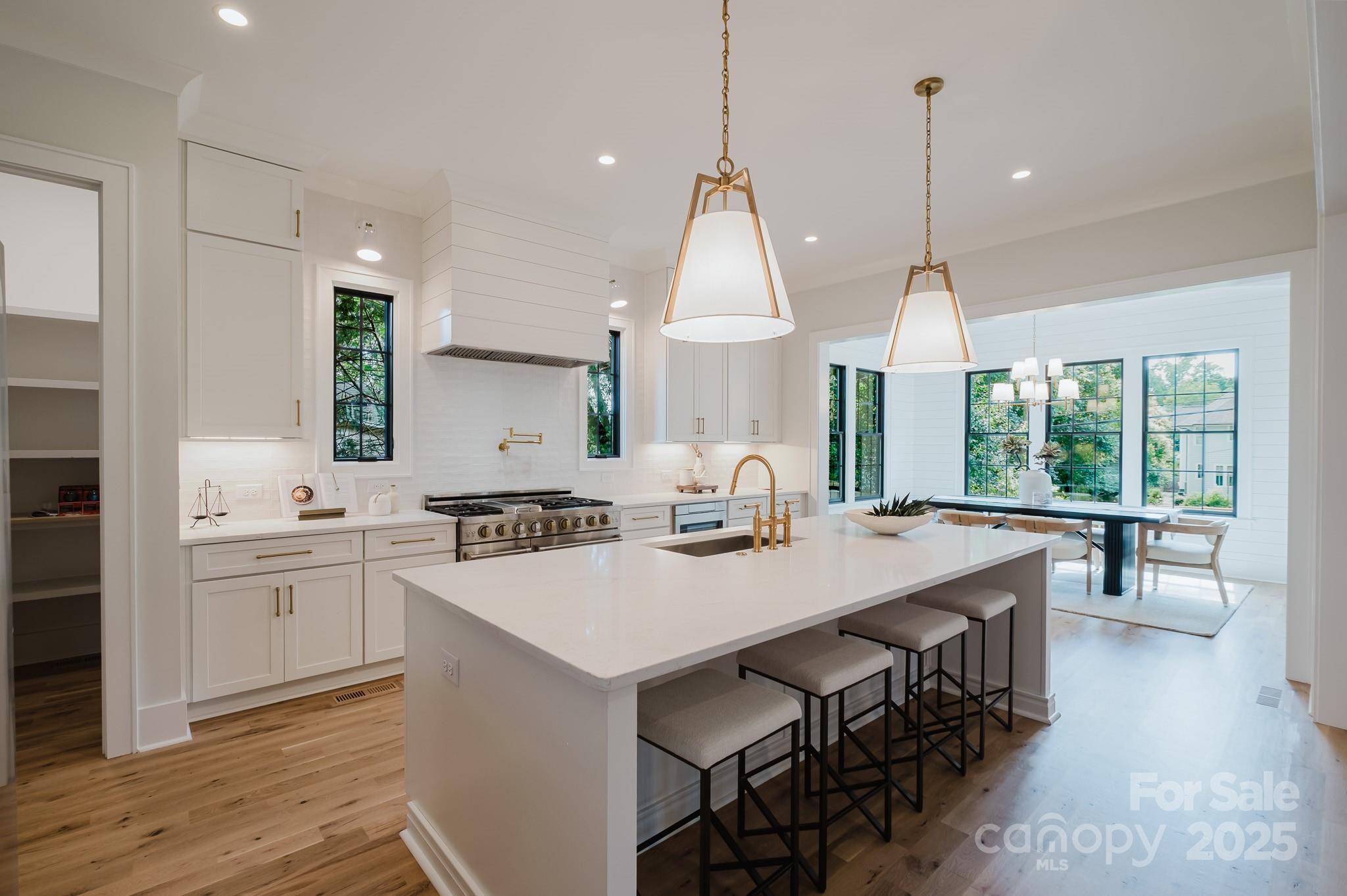 1625 Club Road Charlotte, NC 28205 - Photo 10 of 31 a kitchen with kitchen island a sink dining table and chairs