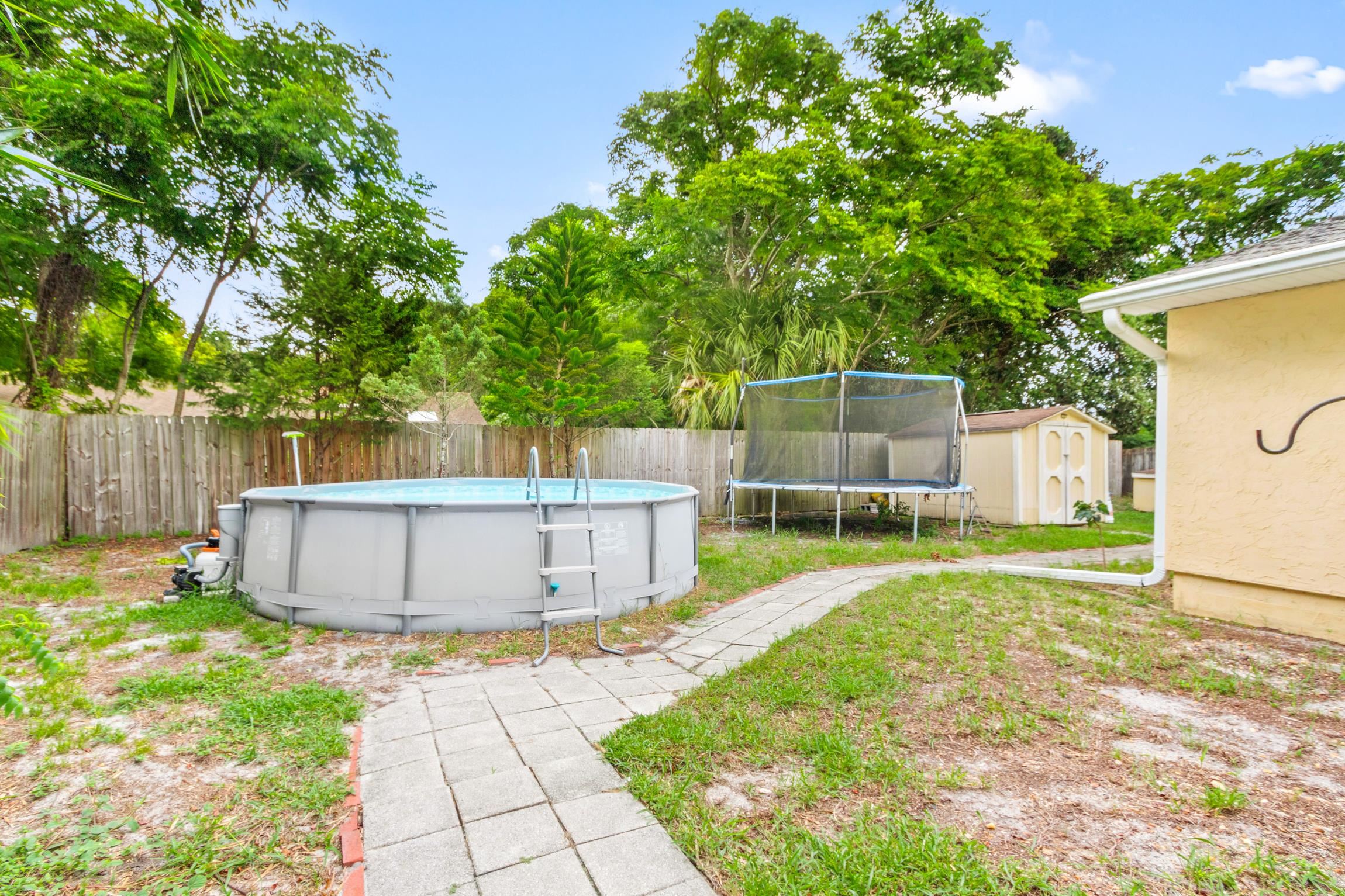 359 Shamrock Road St. Augustine, FL 32086 - Photo 24 of 39 a view of a backyard with large trees and wooden fence