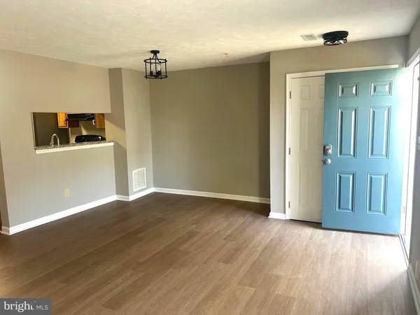 a view of a livingroom with wooden floor and a ceiling fan