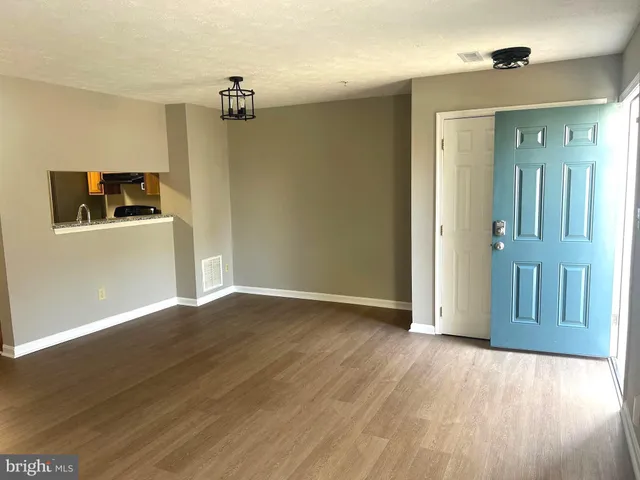 a view of a livingroom with wooden floor and a ceiling fan