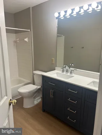 a bathroom with a double vanity sink toilet and shower