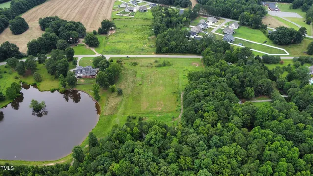 an aerial view of residential house with outdoor space and trees all around
