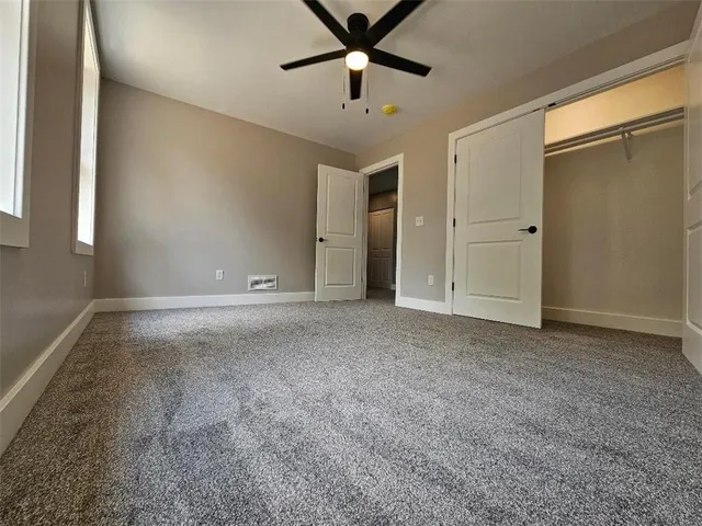 a view of a livingroom with a ceiling fan and window