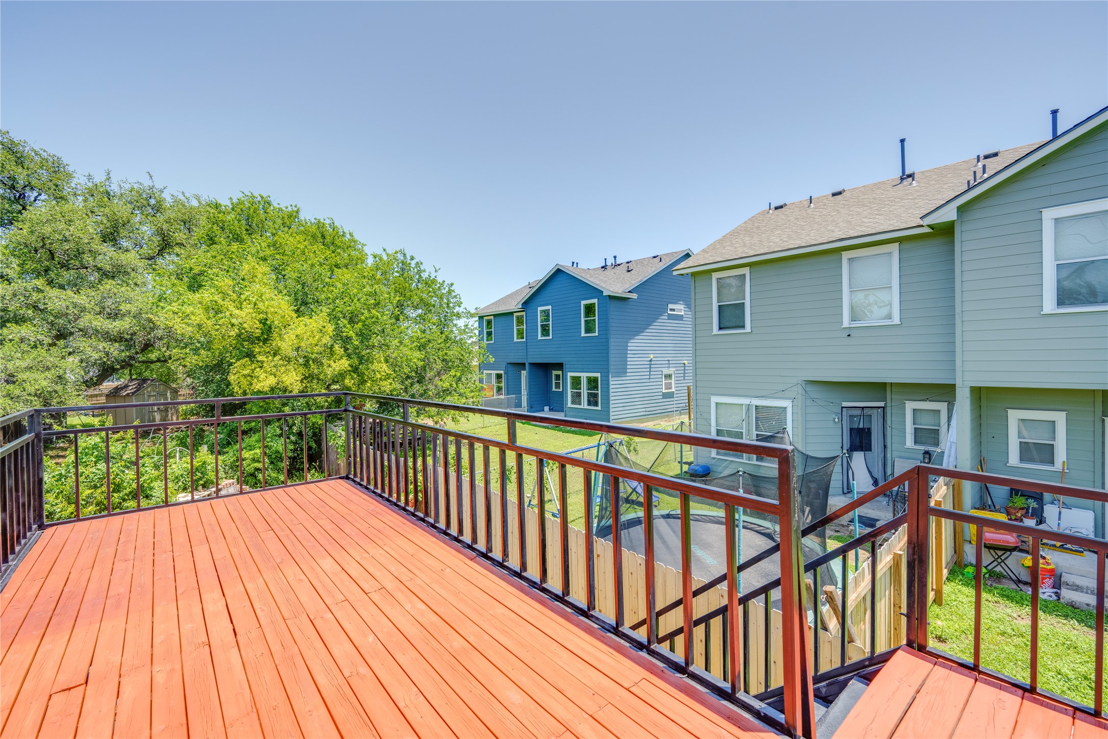 1707 Overhill Drive Austin, TX 78721 - Photo 23 of 36 An elevated wood deck offers views of lush green trees and neighboring residences.