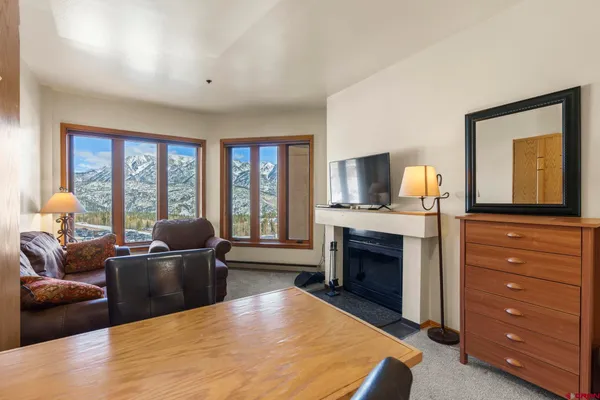 a bedroom with a bed couch and a flat tv screen next to a window