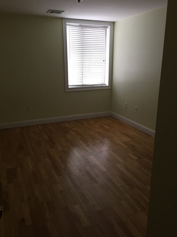 25 Alpine Street, Unit 1 Boston, MA 02136 - Photo 7 of 9 an empty room with wooden floor and windows