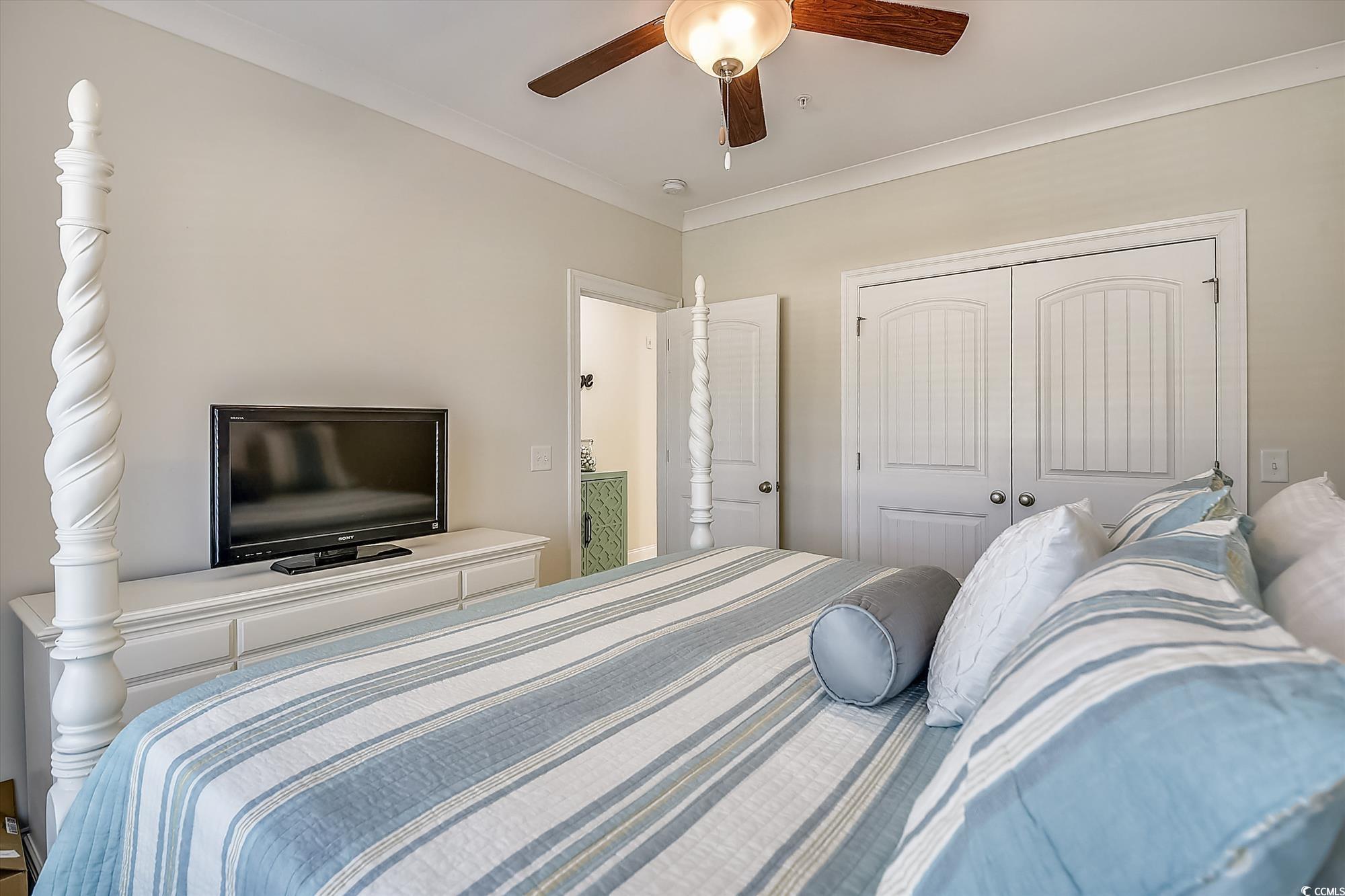 1029 Ray Costin Way, Unit VILLA 906 Murrells Inlet, SC 29576 - Photo 17 of 40 Bedroom featuring a closet, a ceiling fan, and crown molding