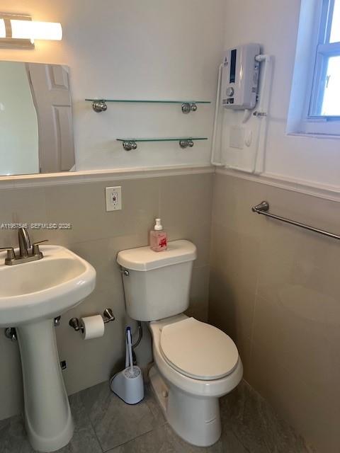1220 Southwest 5th Street, Unit 21 Miami, FL 33135 - Photo 11 of 14 a bathroom with a sink a toilet and a mirror