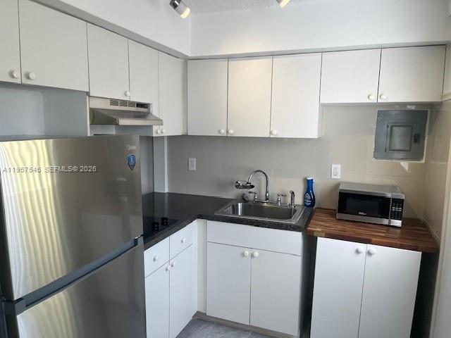 1220 Southwest 5th Street, Unit 21 Miami, FL 33135 - Photo 6 of 14 a kitchen with granite countertop white cabinets and refrigerator