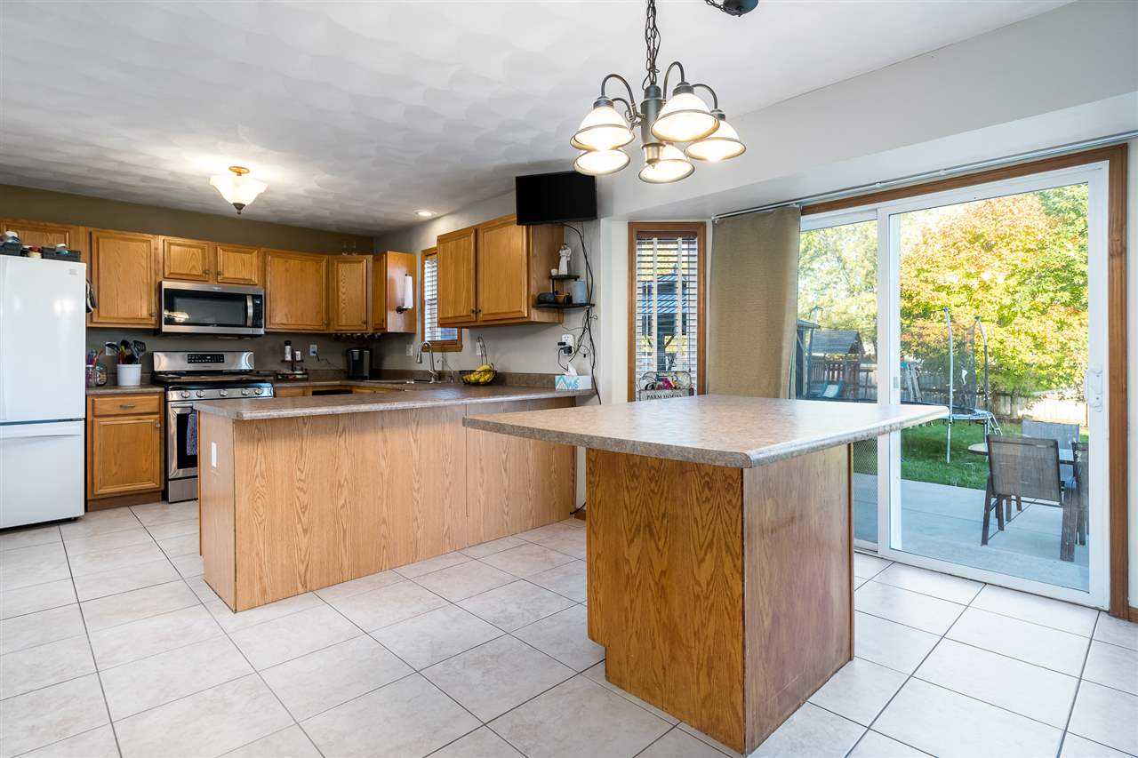 15639 Stonecrest Road South Beloit, IL 61080 - Photo 14 of 37 a kitchen with stainless steel appliances granite countertop a stove a sink a microwave and a refrigerator