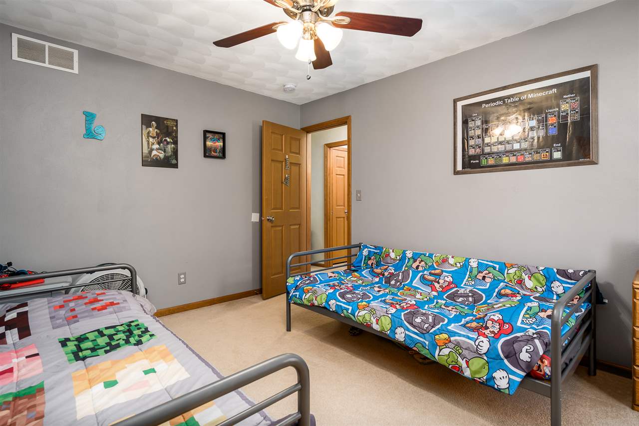15639 Stonecrest Road South Beloit, IL 61080 - Photo 26 of 37 a bedroom with a bed and a chandelier