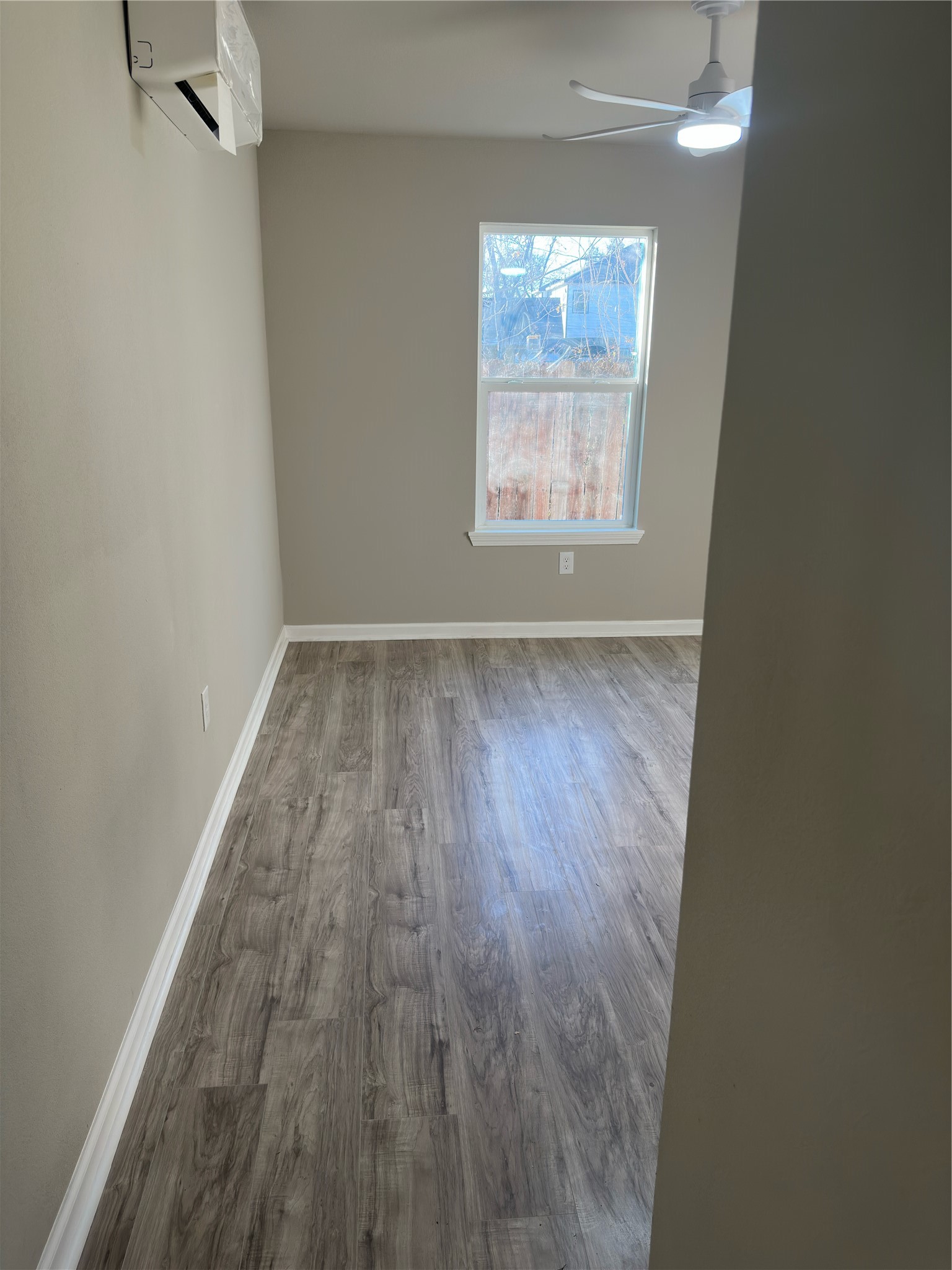 9935 Algiers Road, Unit B Houston, TX 77041 - Photo 6 of 6 an empty room with wooden floor and windows