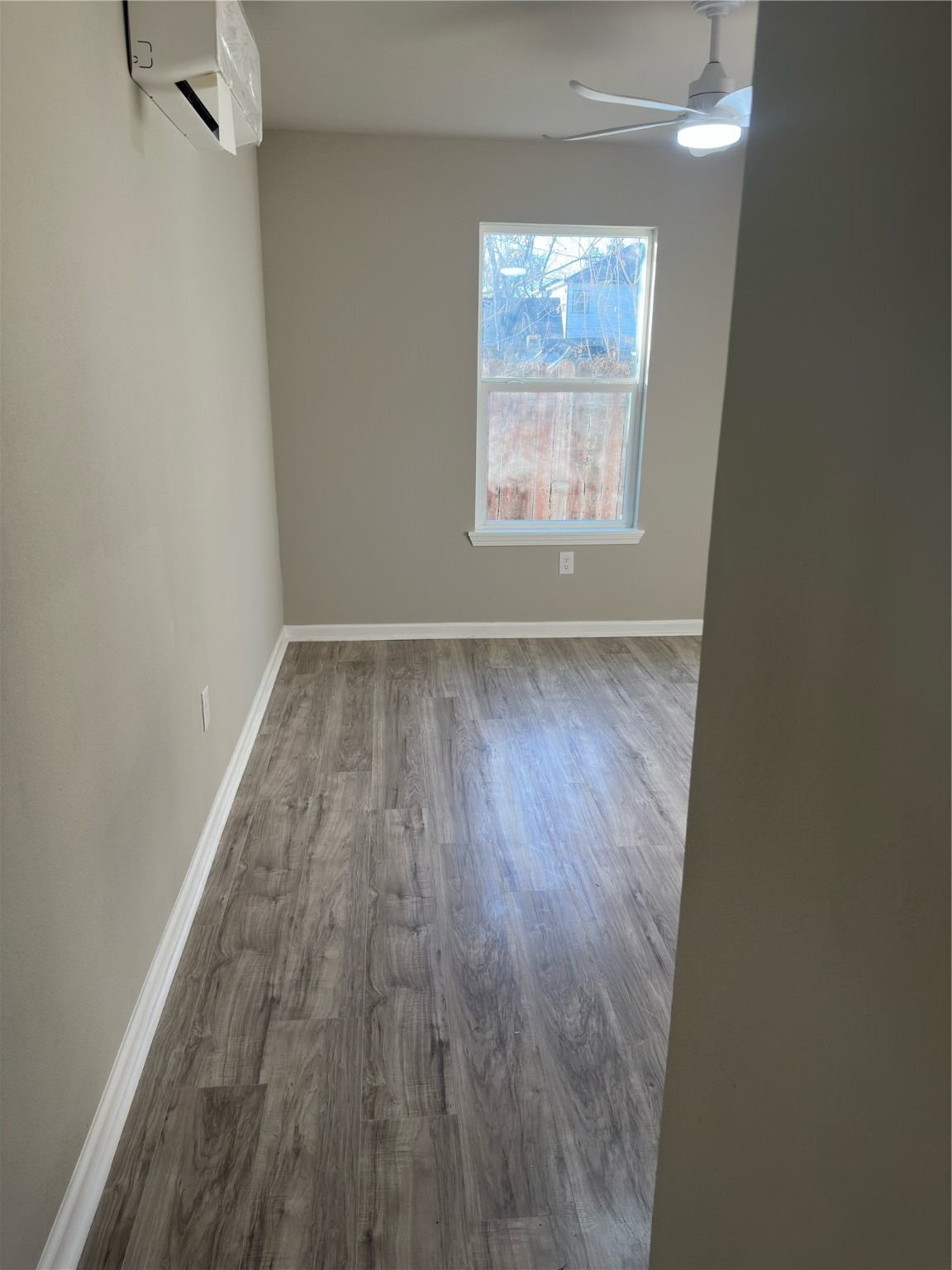 9935 Algiers Road, Unit B Houston, TX 77041 - Photo 6 of 6 an empty room with wooden floor and windows