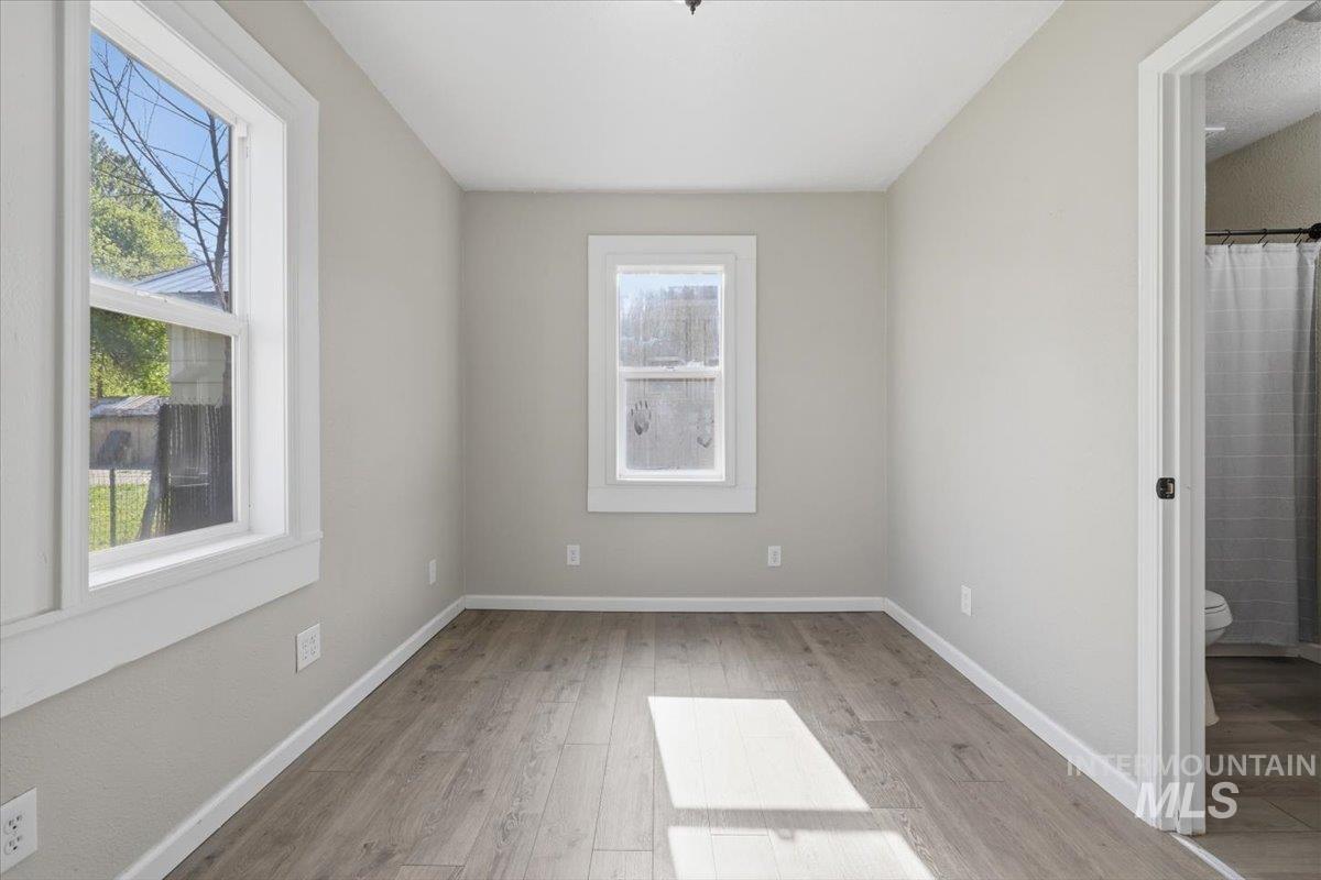 284 Fargo Avenue Notus, ID 83656 - Photo 12 of 24 Neutral-toned room featuring two windows with white trim, wood-finish flooring, and light-colored walls