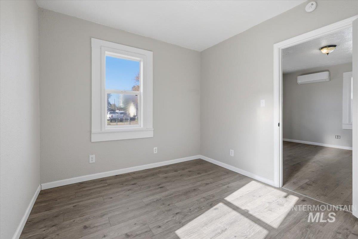 284 Fargo Avenue Notus, ID 83656 - Photo 13 of 24 Interior space featuring wood-finish flooring, light grey painted walls, white trim, and a window with natural light