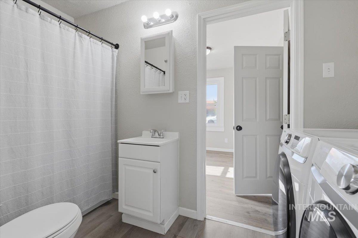 284 Fargo Avenue Notus, ID 83656 - Photo 19 of 24 Bathroom featuring wood-finish flooring, a white vanity with integrated sink, and a wall-mounted medicine cabinet