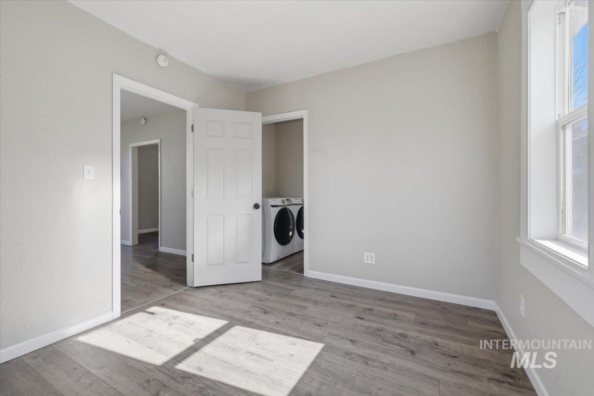 284 Fargo Avenue Notus, ID 83656 - Photo 5 of 24 Laundry area featuring a stackable washer and dryer, wood-finish flooring, and a window for natural illumination