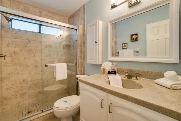 a bathroom with a sink a toilet and shower
