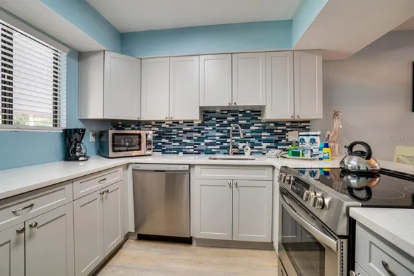 a kitchen with white cabinets and white appliances