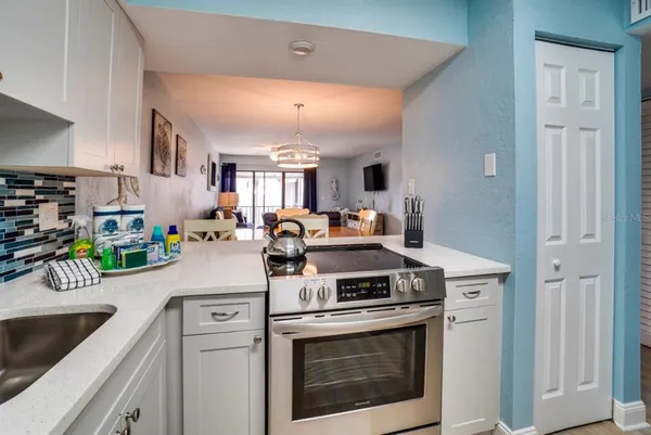 a kitchen with stainless steel appliances granite countertop a stove a sink and a refrigerator