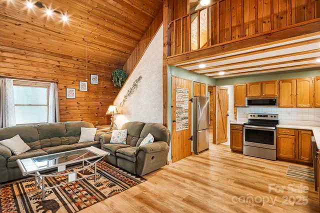 a living room with furniture a fireplace and a floor to ceiling window